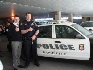 Адвокат Скрябин с сержантом полиции города Репид-Сити Марком Эйзенбрауном у полицейского автомобиля