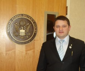 Адвокат Скрябин в зале суда США рядом с печатью суда